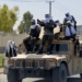 Para pejuang Taliban terlihat berdiri di atas barisan Humvee selama parade sepanjang jalan di Kandahar